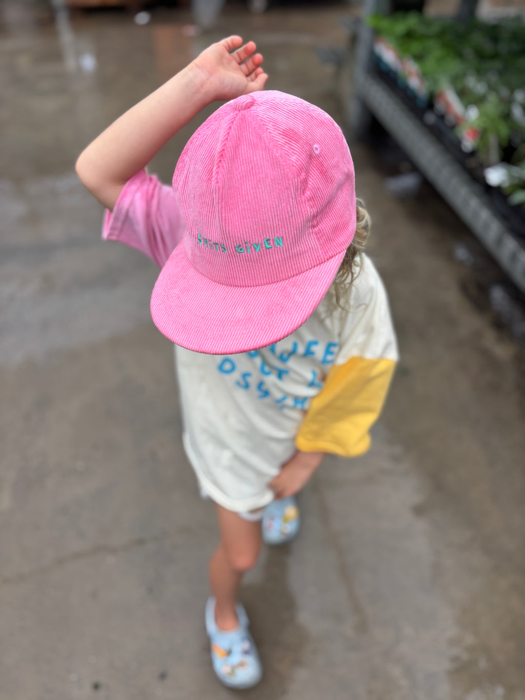 Child wearing pink cap with slogan 